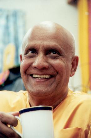 Sri Chinmoy holding cup and smiling